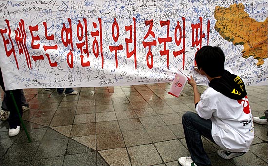 성화봉송 행사에 참가한 중국측 축하객들이 올림픽 공원에서 ´티베트는 영원히 우리 중국땅이다´ 라고 적힌 현수막에 서명하고 있다.
