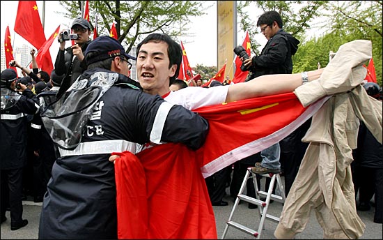한국측 인권단체 주변으로 몰려든 중국측 축하객들이 오성기를 펼쳐들며 뛰어들자 한국 경찰이 이를 제지하고 있다.