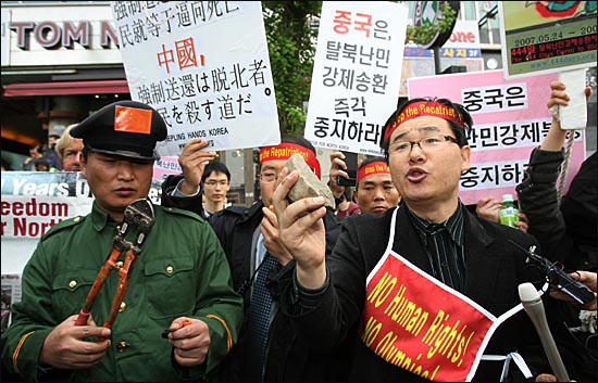 한국 인권단체측에서 중국인들이 던진 절단기와 돌을 들고있다.
