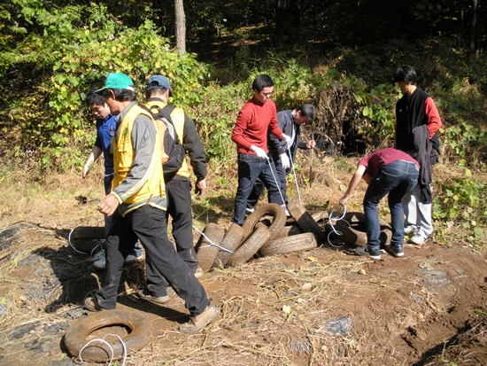 페비닐이 덮여진 밭과  남한산성에서 수거한 쓰레기 폐타이어를 옮기고 있는 태원고 학생들