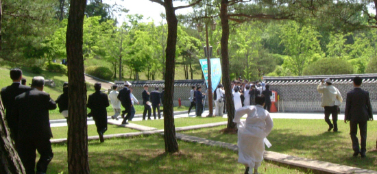 유족회원들이 기념식이 끝나자 박주선 의원에게 몰려가 집단으로 항의한 뒤 경호를 받고 행사장을 빠져 나가는 박 의원을 뒤 쫒고 있다