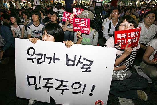 지난 2008년 5월 29일 서울시청 앞 광장에서 촛불문화제를 마친 뒤 명동, 종로, 을지로를 거쳐 광화문 사거리에 도착한 시민들이 경찰버스에 가로막히자 자리에 앉아있다. 