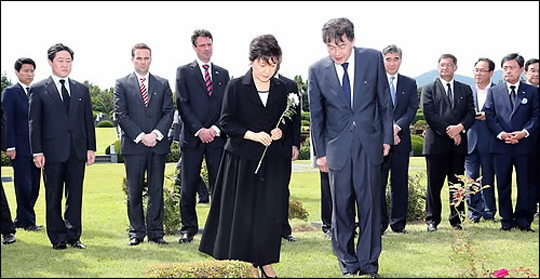 박근혜 대통령이 22일 오후 부산시 남구 대연동 유엔기념공원에서 열린 유엔군 참전­ 및 정전 60주년 유엔참전용사 기념식에 참석, 미국 리처드 위드콤의 묘역을 둘러보며 참배하고 있다. ⓒ연합뉴스