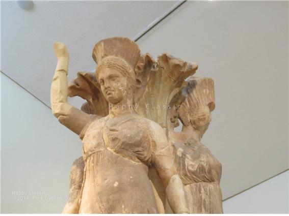 ‘댄서의 원주’의 아름다운 상단 조각이다. 아칸서스 잎과 세 여인의 머리가 육중한 옴파로스를 담은 용기의 하중을 자연스럽게 받드는 구조로 조각되었다. 머리 상부가 안쪽으로 기울게 조상된 점을 주목하라. 델피 고고학 박물관 ⓒ박경귀