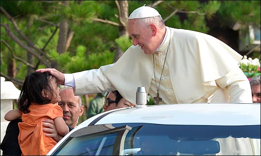 프란치스코 교황이 15일 오후 아시아 청년대회가 열리고 있는 충남 당진시 솔뫼성지를 방문해 이동하며 한 아이의 머리를 만지고 있다. ⓒ사진공동취재단