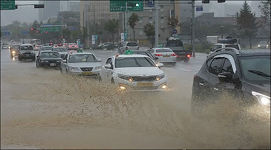 폭우가 내린 21일 강원 춘천시 효자동 도심 도로 곳곳에서 차량들이 서행을 하고 있다. ⓒ연합뉴스