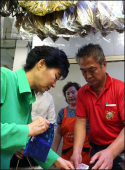 박근혜 대통령이 22일 오후 부산 자갈치시장을 방문, 한 건어물 상점에서 물건을 구매한 뒤 온누리상품권으로 지불하고 있다. ⓒ연합뉴스