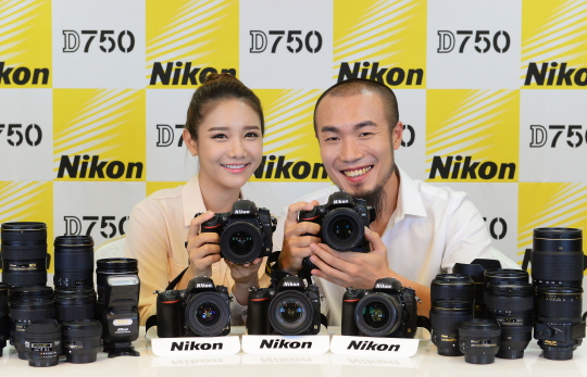 밴드 체리필터의 드러머 손스타(오른쪽)와 니콘 모델이 12일 서울 중구 태평로1가 코리아나호텔에서 열린 행사에서 니콘 DSLR 카메라 D750을 선보이고 있다.ⓒ니콘이미징코리아