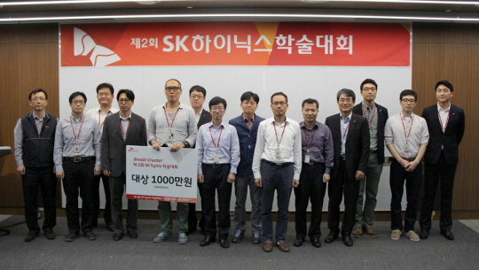 박성욱 SK하이닉스 최고경영자(CEO, 왼쪽에서 일곱번째)와 김용탁 부사장(오른쪽에서 네번째)가 제2회 SK하이닉스 학술대회에서 대상을 수상한 권일웅 책임(왼쪽에서 다섯번째)을 비롯한 수상자들과 기념 촬영을 하고 있다.ⓒSK하이닉스