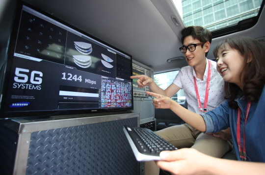 삼성전자 연구원들이 15일 시속 100㎞ 이상으로 달리는 차 안에서 5세대(5G) 이동통신 기술을 시연하고 있다.ⓒ삼성전자 