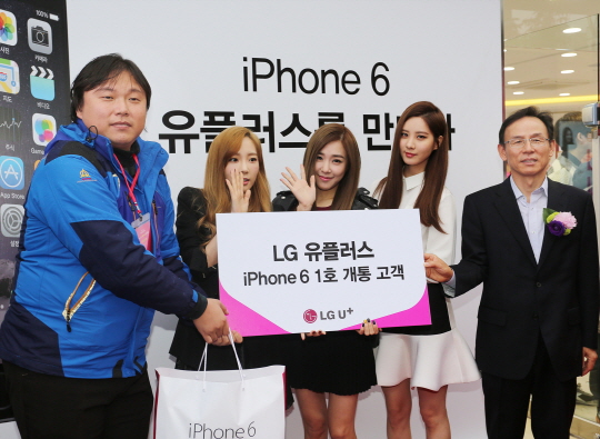 LG유플러스의 아이폰6 1호 가입자 원경훈(왼쪽)과 최주식 SC본부장(오른쪽)이 인기 걸그룹 '태티서'와 함께 기념 촬영을 하고 있다. ⓒLG유플러스