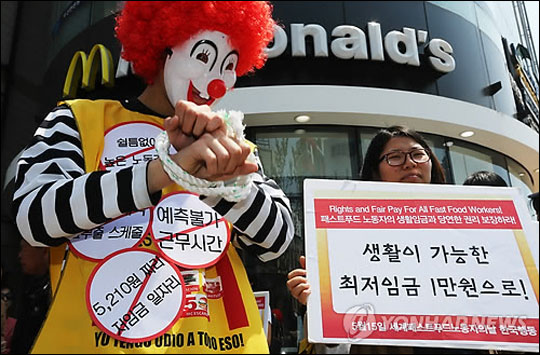 지난 5월 15일 맥도날드 신촌점 앞에서 열린 '세계 패스트푸드 노동자의 날 한국행동'에서 참가자들이 노동권 보장 등을 촉구하며 퍼포먼스를 하고 있다(자료사진) ⓒ연합뉴스