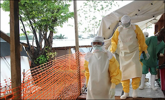 서아프리카 에볼라 발병국 가운데서도 에볼라가 가장 극성인 시에라리온의 카일라훈 국경없는의사회(MSF) 에볼라 치료센터에서 의료종사자들이 바람구멍 하나 없는 보호복 차림으로 격리센터로 들어가고 있다.ⓒ연합뉴스