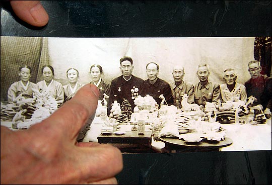 2014년 설 계기 이산가족 상봉을 통해 북측의 가족을 만난 이창주 씨가 북의 조카들이 전해준 사진을 보고 있다. ⓒ데일리안 박항구 기자