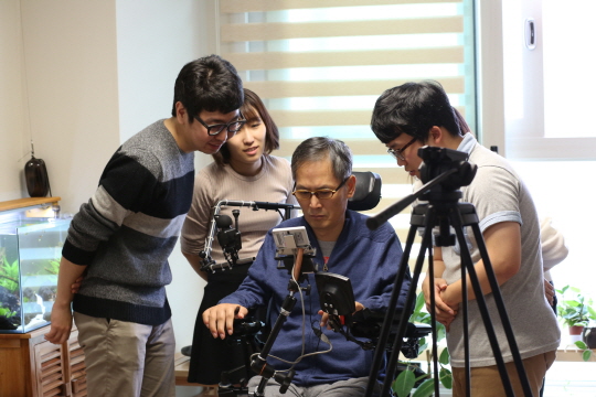 장애인 육근홍씨가 손이나 팔이 불편한 장애인들이 스마트폰을 사용할 수 있도록 도와주는 '두웰'을 이용해 스마트폰을 사용하고 있다. ⓒ삼성전자