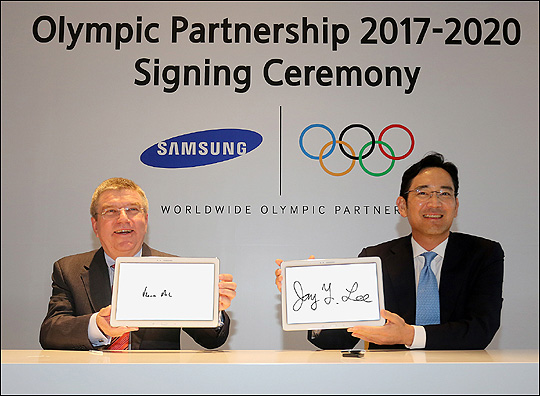 삼성전자 이재용 부회장(사진 오른쪽)이 지난해 8월 중국 난징 페어몬트 호텔에서 열린 올림픽 후원 계약식에서 IOC 토마스 바흐 위원장과 계약서에 사인한 뒤 삼성 태블릿에 기념 서명을 하고 있다. ⓒ삼성전자