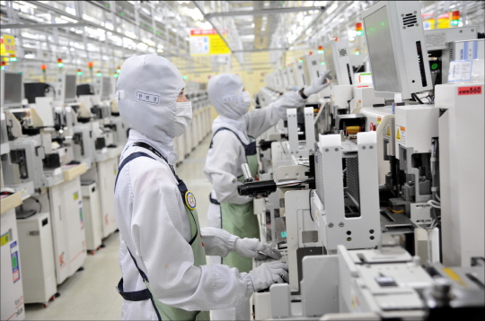 삼성전자 반도체 생산라인 직원들이 제품을 살펴보고 있다. ⓒ삼성전자