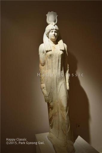 이집트의 신 이시스 상, 왼손에 밀 이삭을 들고 있다. 장미송이를 들고 있었을 오른손은 멸실되었다. 마라톤 고고학 박물관 ⓒ박경귀 