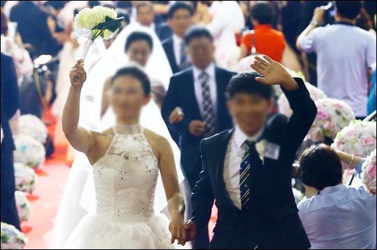 지난 6월 30일 오후 서울 송파구 올림픽공원 SK핸드볼경기장에서 열린 광복 70주년 '북한이탈주민 100쌍 합동결혼식'에서 신랑·신부들이 행진하고 있다. ⓒ데일리안 홍효식 기자