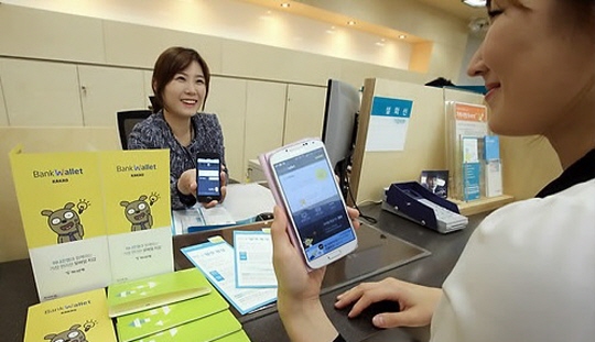 서울 을지로 하나은행 지점 직원들이 모바일 금융 서비스 '뱅크 월렛 카카오'를 이용하고 있다. ⓒ 연합뉴스