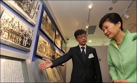 박근혜 대통령이 4일 상하이에서 열린 대한민국 임시정부청사 재개관식에서 방명록 서명공간에 설치된 전시물에 대한 설명을 듣고 있다.ⓒ연합뉴스