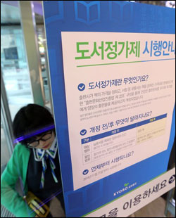 도서정가제가 시행된 21일 서울 광화문 교보문고에서 직원이 도서정가제 시행 안내문을 출입문에 부착하고 있다. ⓒ연합뉴스