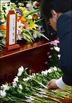 22일 서울 종로구 서울대병원 장례식장에 마련된 고 김영삼 전 대통령 빈소를 찾은 조문객이 고인의 영전 앞에 국화꽃을 놓고 있다. ⓒ사진공동취재단