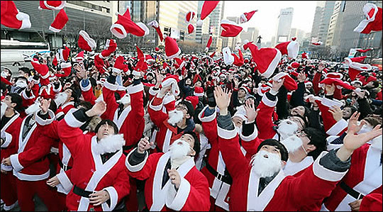 크리스마스 이브인 24일 오후 서울 종로구 광화문 광장에서 열린 '2014 사랑의 몰래산타 사랑의 대작전' 출정식에서 산타 복장을 한 예비산타들이 모자를 던지고 있다. ⓒ연합뉴스