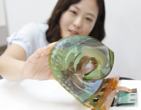 LG디스플레이 한 직원이 18인치 플렉시블 OLED 패널을 말아보이고 있다.ⓒLG디스플레이