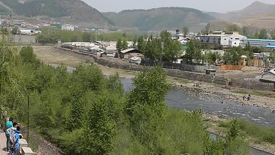 창바이현(사진 속 강을 중심으로 왼쪽)에서 관광객들이 압록강 너머 북한 양강도 혜산시를 바라보는 모습. ⓒ연합뉴스