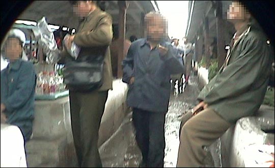 북한의 한 장마당에서 사람들이 물건을 살펴보고 있다.(자료사진).North korea VJ 캡처