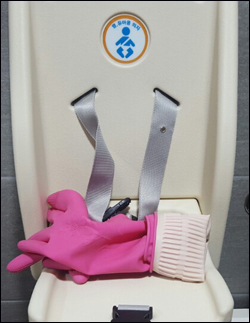 이비스앰배서더 서울 동대문 1층 여성 장애인화장실 영유아 의자에 지난달 30일 고무장갑이 놓여 있다. ⓒ데일리안