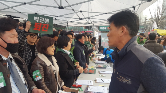 국민의당이 3일 광화문광장 인근에서 '박근혜 대통령 퇴진 촉구 서명' 행사를 벌이는 도중 한 시민이 탄핵안 처리를 미뤄졌다고 주최 측에 강하게 항의하고 있다. ⓒ데일리안