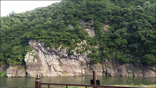 강 건너에 보이는 반구대 암각화(절벽 중앙 편편한 바위에 암각화가 새겨져 있다).ⓒ조남대
