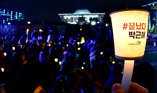 박근혜 대통령 탄핵소추안 국회 본회의 표결을 하루 앞둔 8일 저녁 국회 앞에서 열린 촛불집회에서 참가자들이 탄핵을 촉구하는 촛불을 들고 있다. ⓒ데일리안