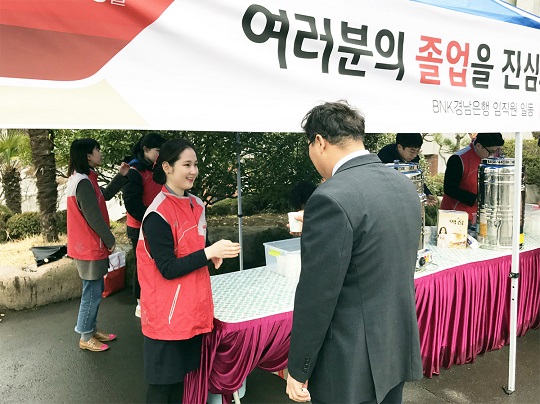 20일 BNK경남은행 직원들이 경남대학교에서 졸업식 축하 행사를 실시하고 있다 ⓒBNK경남은행