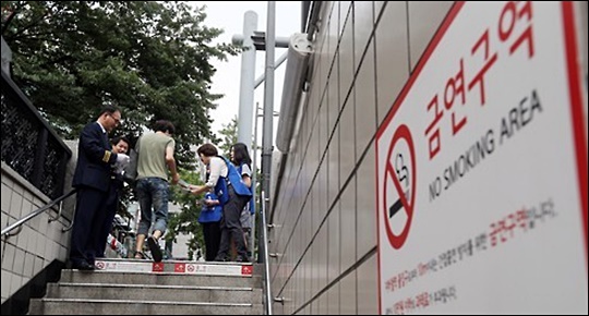 서울시는 지난해 5월 시내 모든 지하철역 출입구 10m 이내를 금연구역으로 지정, 해당 구역 바닥에 거리 제한을 두는 그림문자 스티커를 붙이고 그해 9월부터 본격 단속을 실시했다.(자료사진) ⓒ연합뉴스