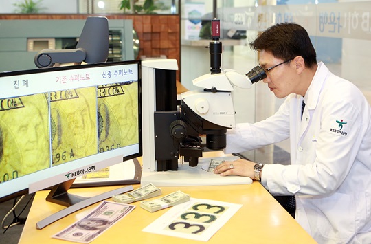 KEB하나은행 위변조대응센터 직원이 전자 현미경을 통해 미국 달러화 지폐의 진폐 여부를 감별하고 있다.ⓒKEB하나은행
