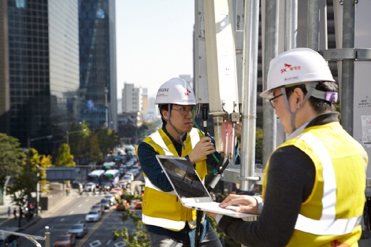 SK텔레콤 5G연구원들이 서울 명동의 건물 옥상에 설치된 5G 기지국에서 LTE-5G장비 주파수 연동 결과를 측정하고 있다. ⓒ SKT