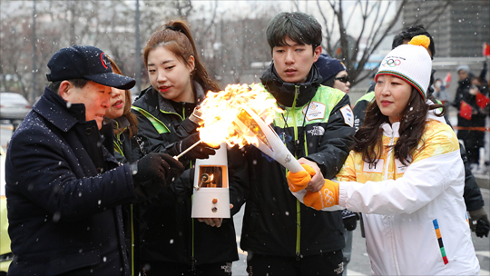 평창 동계올림픽 성화가 서울에 도착한 13일 서울 마포구 디지털미디어시티에서 서울지역 첫번째 성화봉송 주자가 박홍섭 마포구청장으로부터 성화를 전달 받고 있다. ⓒ데일리안 홍금표 기자