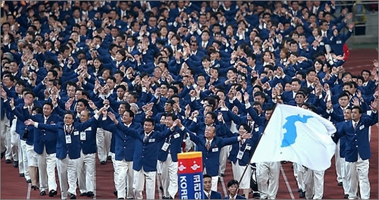 지난 2002년 9월 부산아시안게임 개막식에 공동기수 황보성일(한국 남자핸드볼)과 리정희(북한 여자축구)가 흰바탕에 파란 색깔의 한반도기를 들고 입장하고 있다. ⓒ연합뉴스