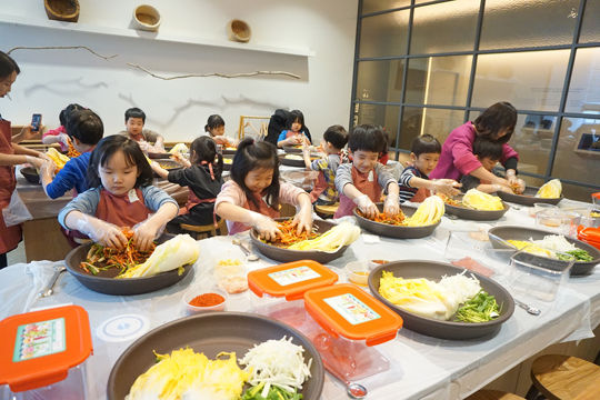 뮤지엄김치간에서 ‘어린이 김치학교’에 참여한 어린이들이 통배추김치 담그기 체험을 하고 있다.ⓒ풀무원
