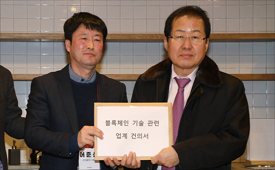 홍준표 자유한국당 대표가 24일 서울 강남구 브이플렉스 창업기업 소통라운지에서 열린 '블록체인과 가상화폐의 미래' 간담회에서 블록체인 업체 및 연구단체 관계자들의 블록체인 기술 관련 업계 건의서를 받고 있다. ⓒ데일리안 홍금표 기자