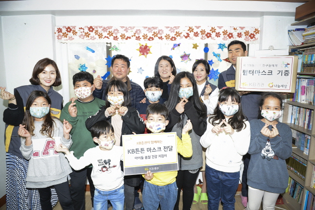 KB증권 직원들이 19일 서울 마포 지역 인근 아동센터를 방문해 KB튼튼마스크를 전달하고 아동센터 관계자 및 어린이들과 기념촬영을 하고 있다.ⓒKB증권