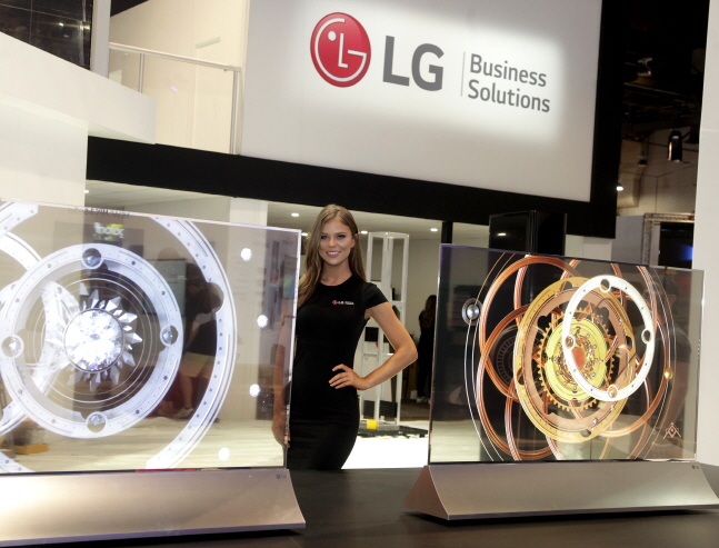 LG전자 모델이 미국 라스베이거스에서 개최된 '인포콤 2108' LG전자 전시부스에서 '투명 올레드 사이니지'를 소개하고 있다.ⓒLG전자