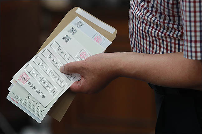 6.13지방선거 및 국회의원 재보궐선거 사전투표가 시작된 8일 사전투표소에서 한 시민이 투표용지를 들고 순서를 기다리고 있다. ⓒ데일리안 류영주 기자