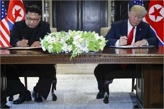 도널드 트럼프(오른쪽) 미국 대통령과 김정은 북한 국무위원장이 지난 12일 북미정상회담 합의문에 서명하고 있다. ⓒCNN