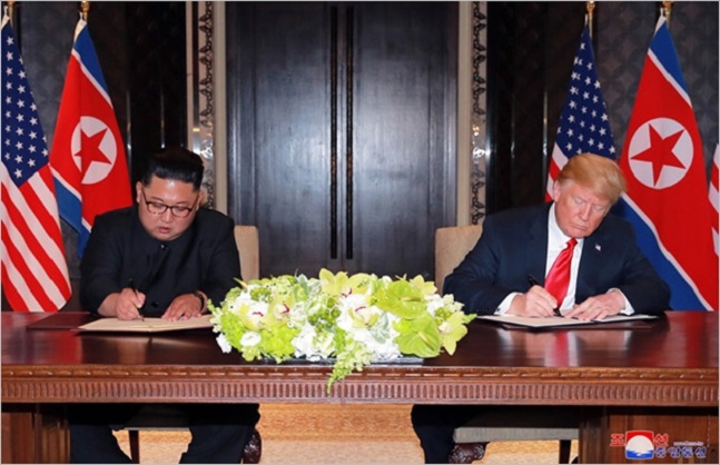 김정은 북한 국무위원장과 도널드 트럼프 미국 대통령이 지난 12일 싱가포르에서 개최된 북미정상회담에서 공동 합의문에 서명하고 있다. ⓒ조선중앙통신