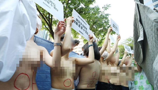 2일 오후 서울 강남구 페이스북코리아 앞에서 여성단체 '불꽃페미액션' 회원들이 페이스북의 성차별적 규정에 항의하는 상의 탈의 시위를 하고 있다. 이 단체는 앞서 페이스북이 남성의 반라 사진은 그대로 두면서 여성의 반라 사진만 삭제하는 점을 규탄하기 위해 기자회견을 열었다고 밝혔다.ⓒ연합뉴스 