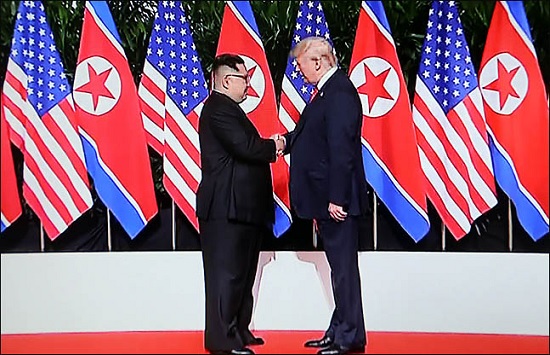 도널드 트럼프 미국 대통령과 김정은 북한 국무위원장이 지난 12일 싱가포르 카펠라 호텔에서 역사적인 첫 북미정상회담에 앞서 악수를 하고 있다./jtbc 화면촬영 ⓒ데일리안